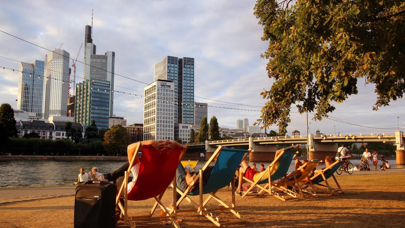 Personen in Liegestühlen am Mainufer in der Innenstadt: Frankfurt hat 2018 einen Wärmerekord für Deutschland aufgestellt.