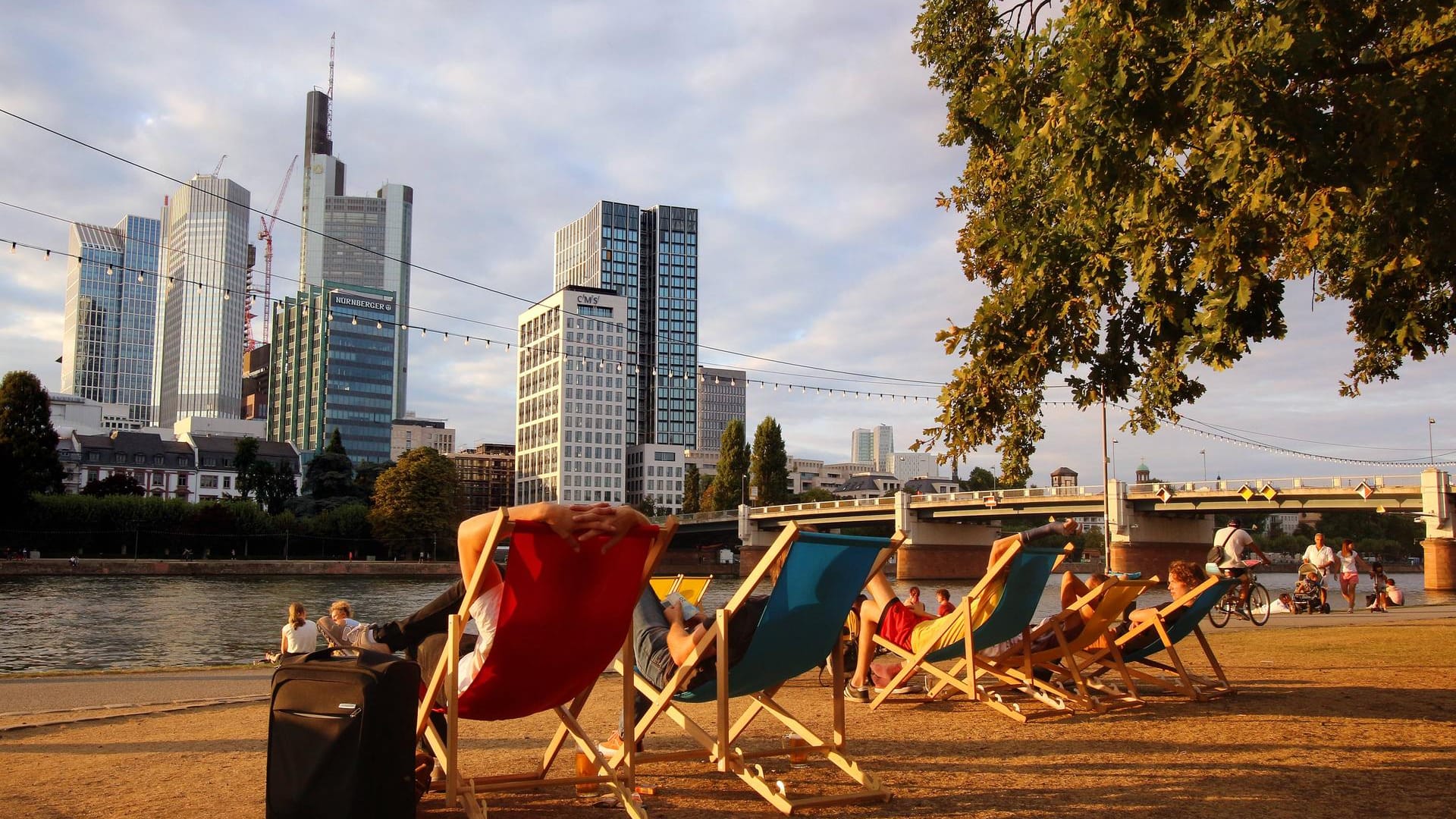 Personen in Liegestühlen am Mainufer in der Innenstadt: Frankfurt hat 2018 einen Wärmerekord für Deutschland aufgestellt. Personen in Liegestühlen am Mainufer in der Innenstadt: Frankfurt hat 2018 einen Wärmerekord für Deutschland aufgestellt.
