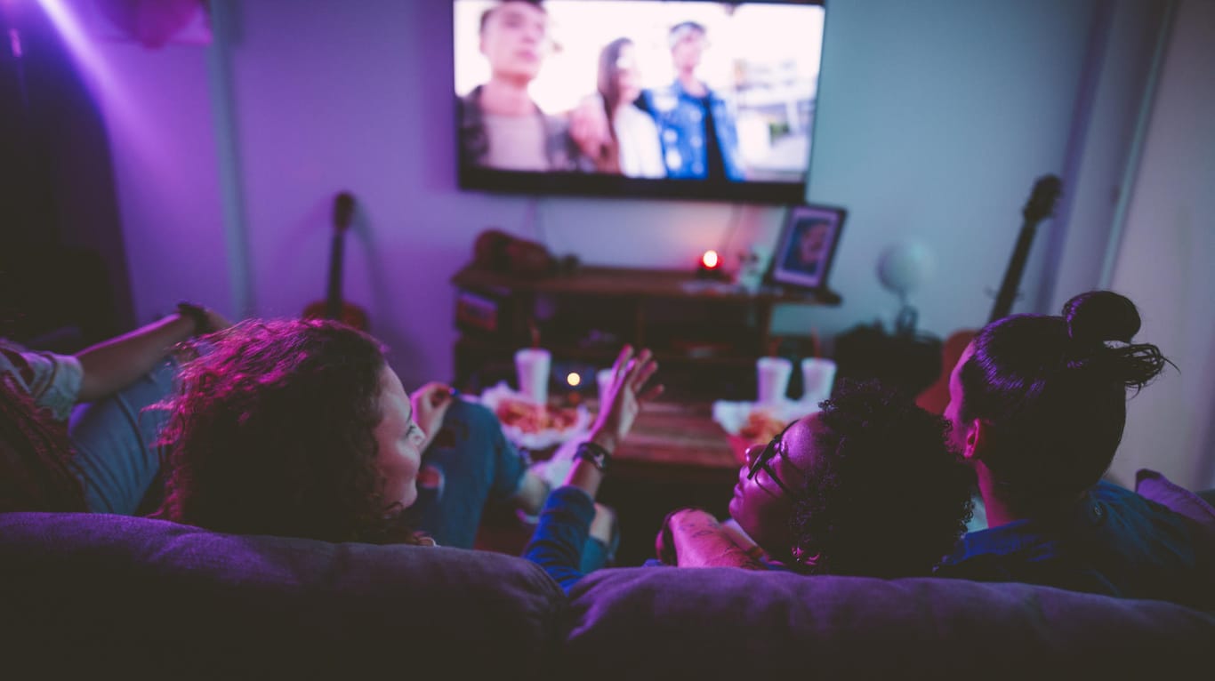 Freunde schauen sich gemeinsam einen Film an: Die Deutschen geben im Durchschnitt mehr als 600 Euro für einen neuen Fernseher aus.
