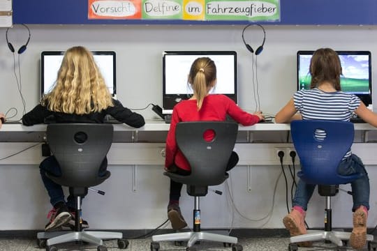 Schüler arbeiten im Klassenraum einer Grundschule an Computern.