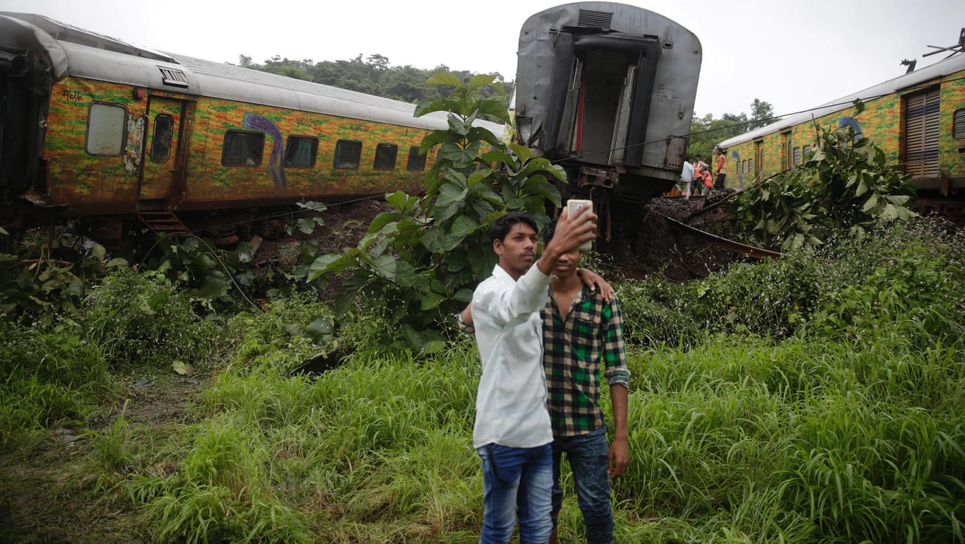 Zwei indische Jungen machen ein Selfie vor dem Bahngleis, auf dem es zuvor zur teilweisen Entgleisung eines Personenzuges kam. Mehr als 30 Inder sterben jedes Jahr beim Selfie-Machen.