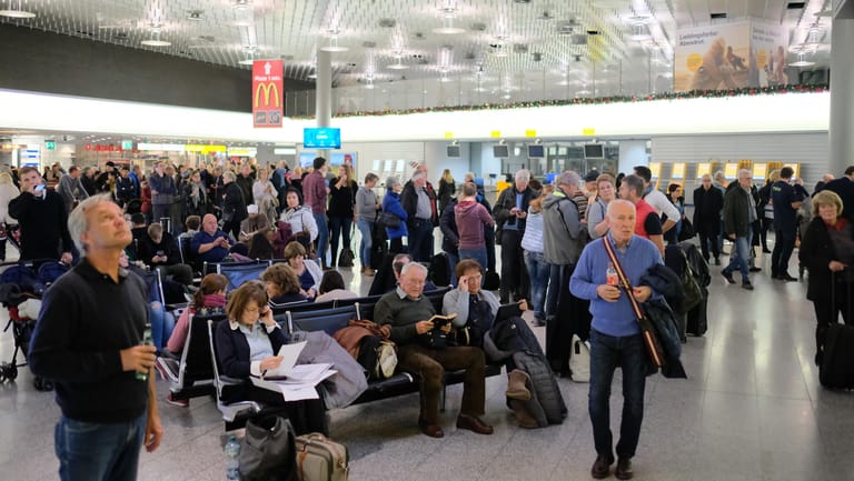 Flughafen Hannover: Reisende warten nach der Einstellung des Flugverkehrs in einer Abflughalle.