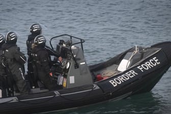 Mitglieder des britischen Grenzschutzes fahren durch den Hafen von Dover auf einem Schlauchboot.