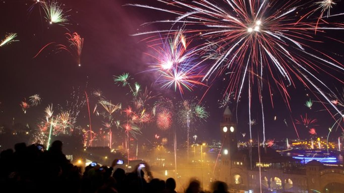 Tausende Menschen begrüßen an den Hamburger Landungsbrücken mit einem Feuerwerk das neue Jahr.
