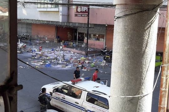 Polizisten untersuchen das Gelände vor einem Einkaufszentrum nach der Bombenexplosion.