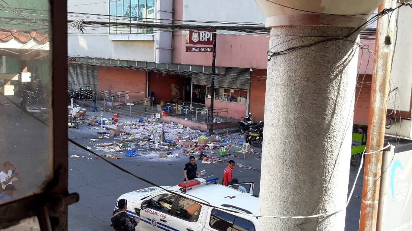 Polizisten untersuchen das Gelände vor einem Einkaufszentrum nach einer Bombenexplosion: Bei der Bombe soll es sich um einen selbstgebauten Sprengkörper handeln.