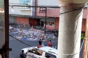 Polizisten untersuchen das Gelände vor einem Einkaufszentrum nach einer Bombenexplosion: Bei der Bombe soll es sich um einen selbstgebauten Sprengkörper handeln.