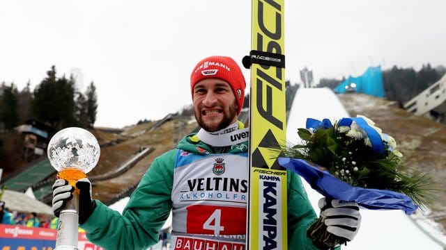 Markus Eisenbichler jubelt mit Pokal über seinen zweiten Platz.