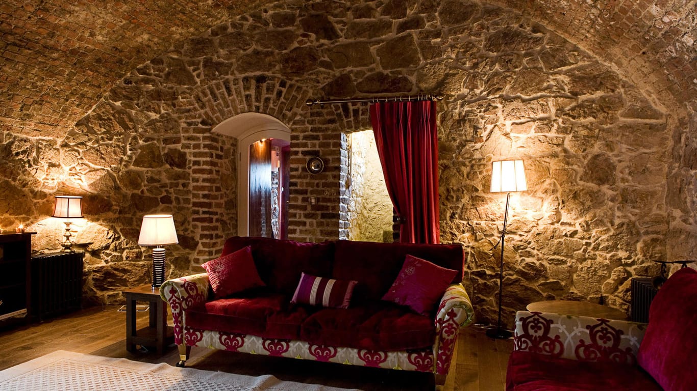 Ferienwohnung im Martello Tower: Der Wohnbereich ist mit Sofas und stimmungsvoller Beleuchtung ausgestattet.
