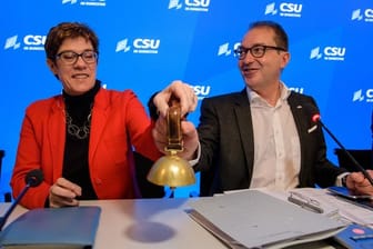 Alexander Dobrindt und Annegret Kramp-Karrenbauer läuten gemeinsam das Glöckchen zur Eröffnung des Gesprächs bei der CSU-Winterklausur im Kloster Seeon.