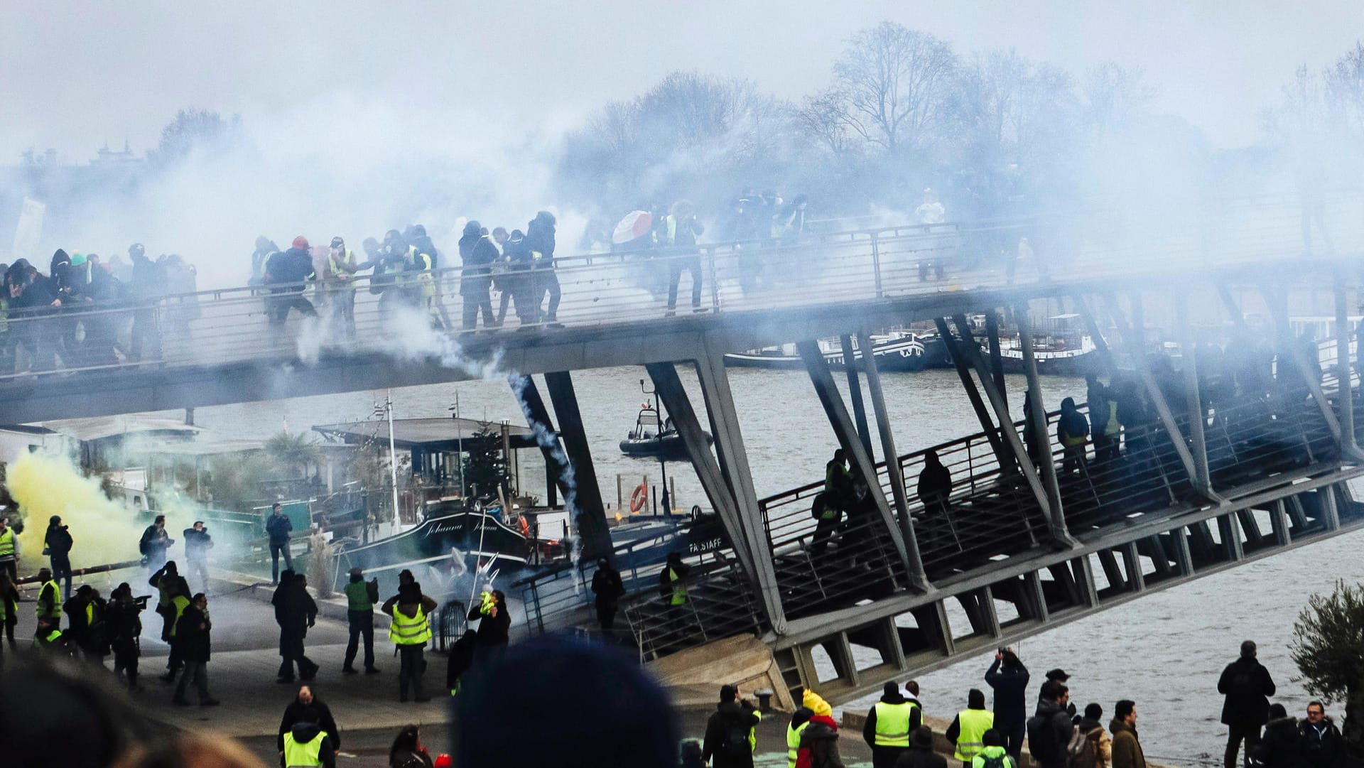 Auf einer Fußgängerbrücke über die Seine gehen Polizisten mit Tränengas gegen "Gelbwesten" vor: Landesweit beteiligten sich wieder mehr Menschen an den Protesten.