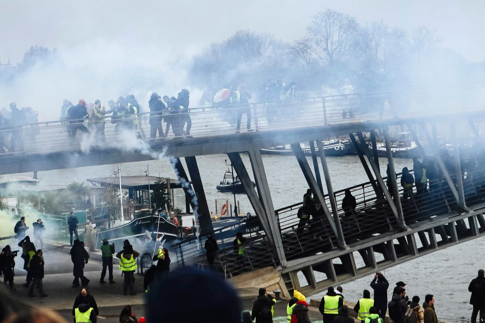 Auf einer Fußgängerbrücke über die Seine gehen Polizisten mit Tränengas gegen "Gelbwesten" vor: Landesweit beteiligten sich wieder mehr Menschen an den Protesten.