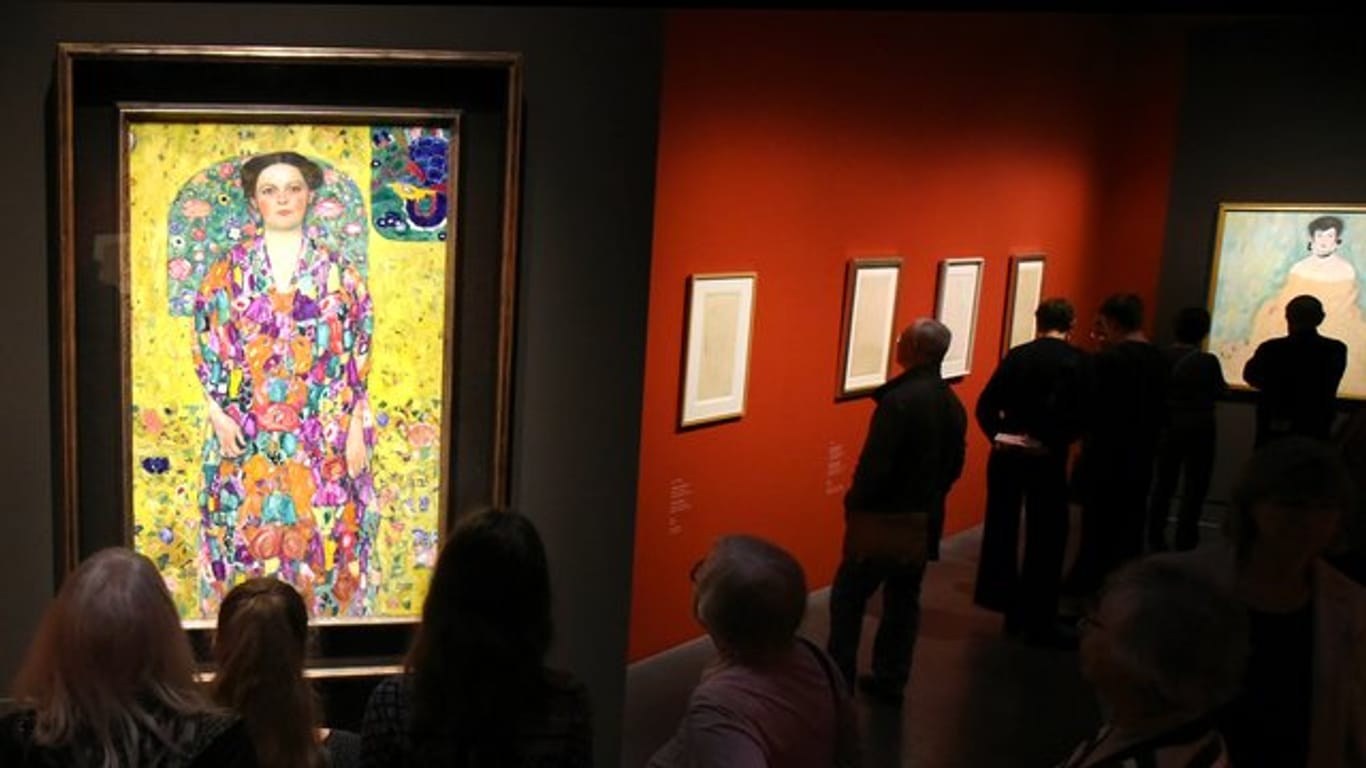 Besucher betrachten im Kunstmuseum Moritzburg Werke des Malers Gustav Klimt.