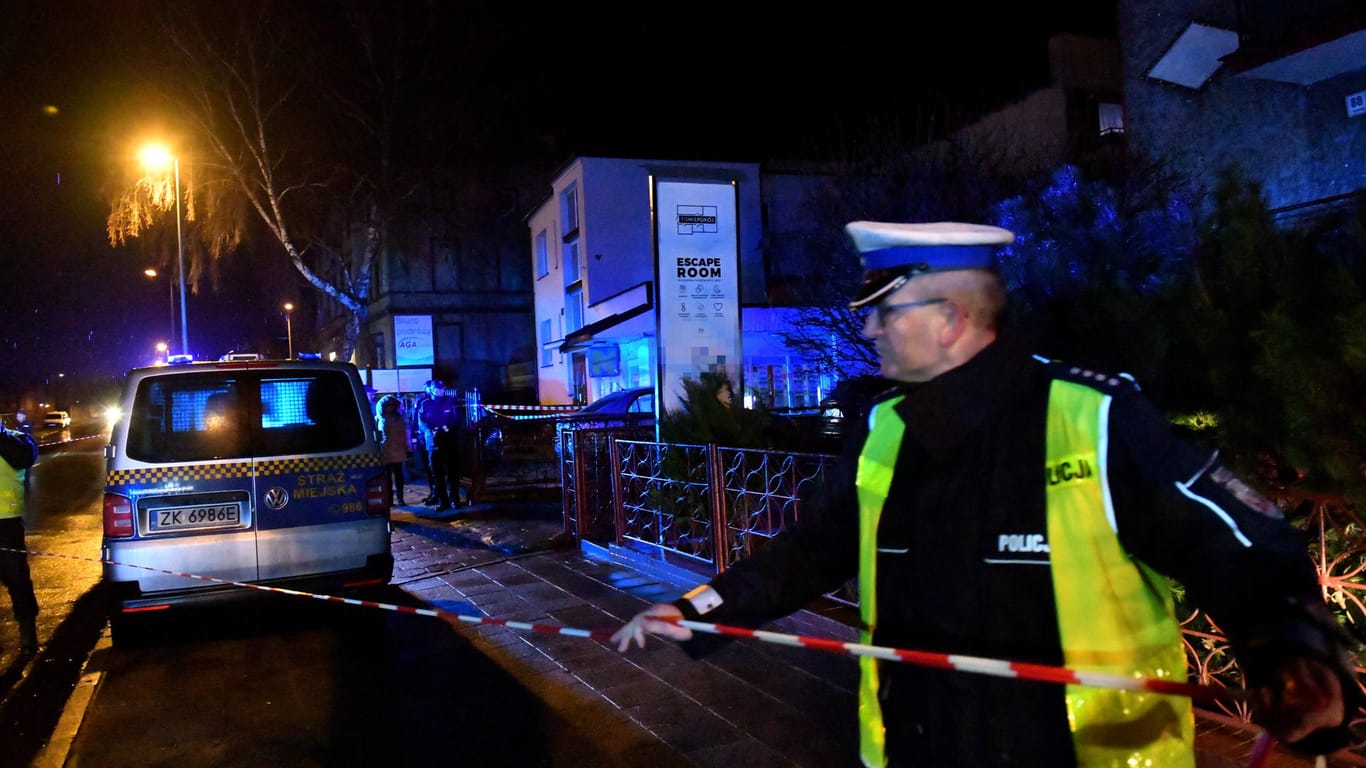 Ein Polizist am Ort des Brandes im polnischen Koszalin: Nach dem Tod fünf 15-jähriger Mädchen ist der Besitzer des Escape Rooms festgenommen worden.