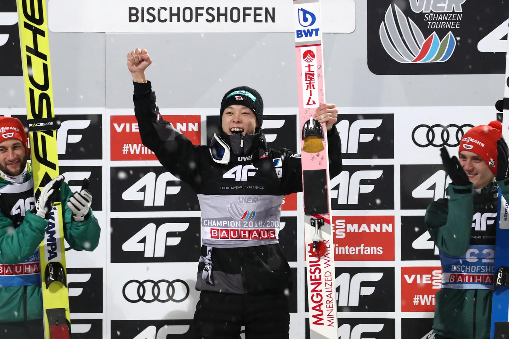 Markus Eisenbichler (links) und Stephan Leyhe (rechts) aus Deutschland applaudieren dem Gesamtsieger Ryoyu Kobayashi aus Japan.