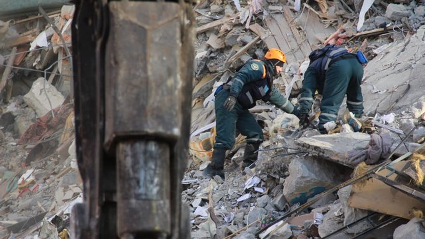Rettungskräfte arbeiten an der Stelle, an der eine Gasexplosion das Wohngebäude teilweise zerstört hat.