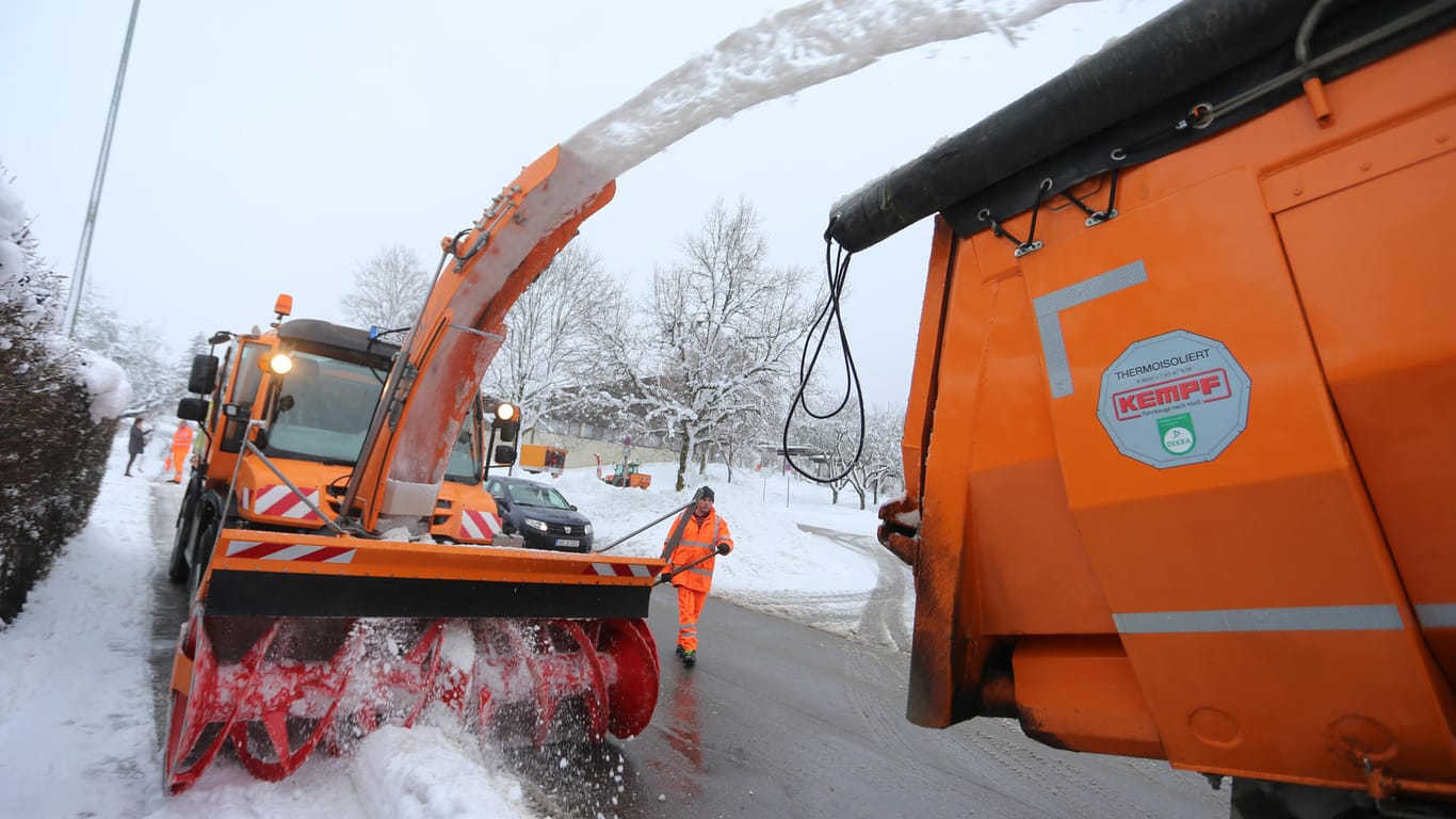 Bayern, Friesenried: Eine Schneefräse vom Winterdienst verfrachtet den Schnee an den Straßen auf einen Lkw.