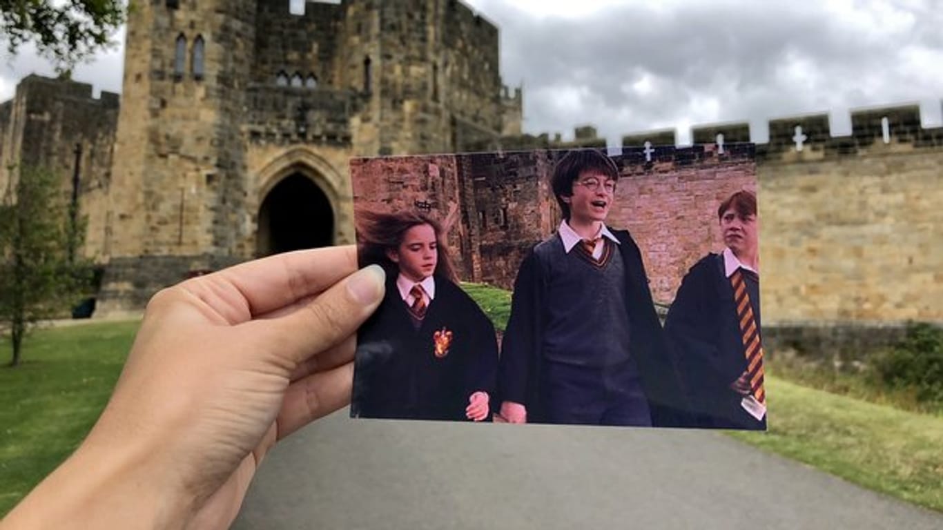 Die Filmtouristin Andrea David hält ein Foto aus dem Film "Harry Potter" in die Kamera.