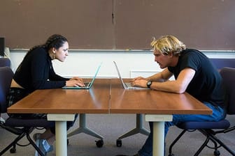 Zwei Studenten der San Francisco State University zeigen, wie Menschen ihren Hals am Computer zusammendrücken.