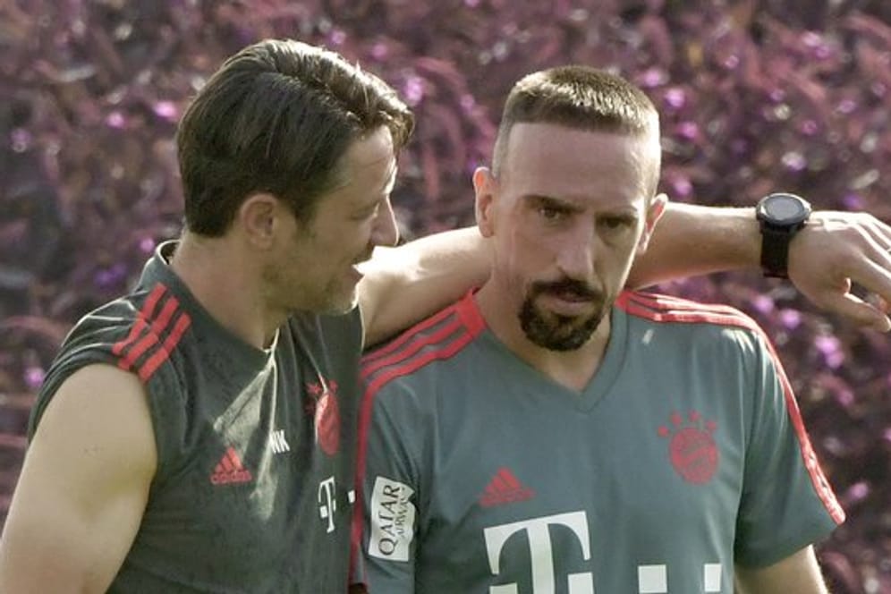 Bayern-Trainer Niko Kovac (l) und Franck Ribery gehen bei einer Übungseinheit zusammen über den Platz.