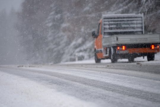 Ein Auto fährt bei Schneefall