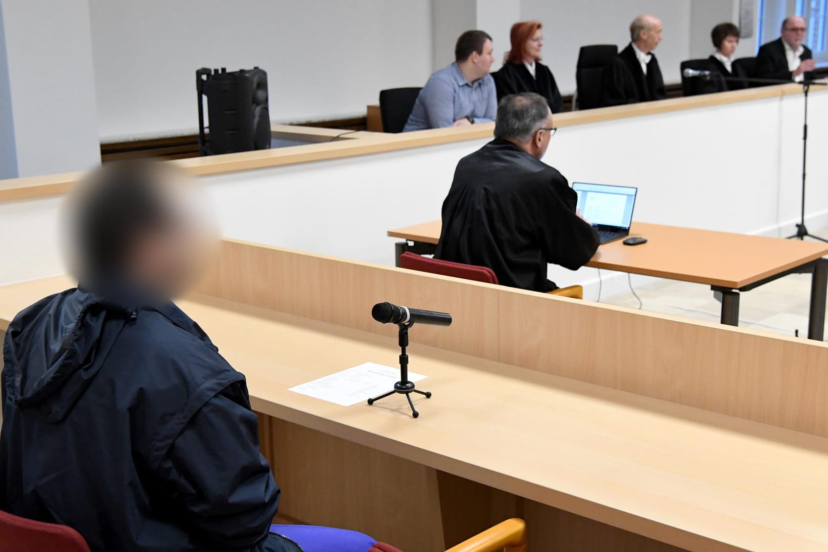 Der Angeklagte sitzt beim Auftakt im Sicherungsverfahren wegen 48-fachen versuchten Mordes im Gerichtssaal: Der psychisch kranke 34-Jährige soll Fahrgäste mit Messerstichen zum Teil lebensgefährlich verletzt haben.