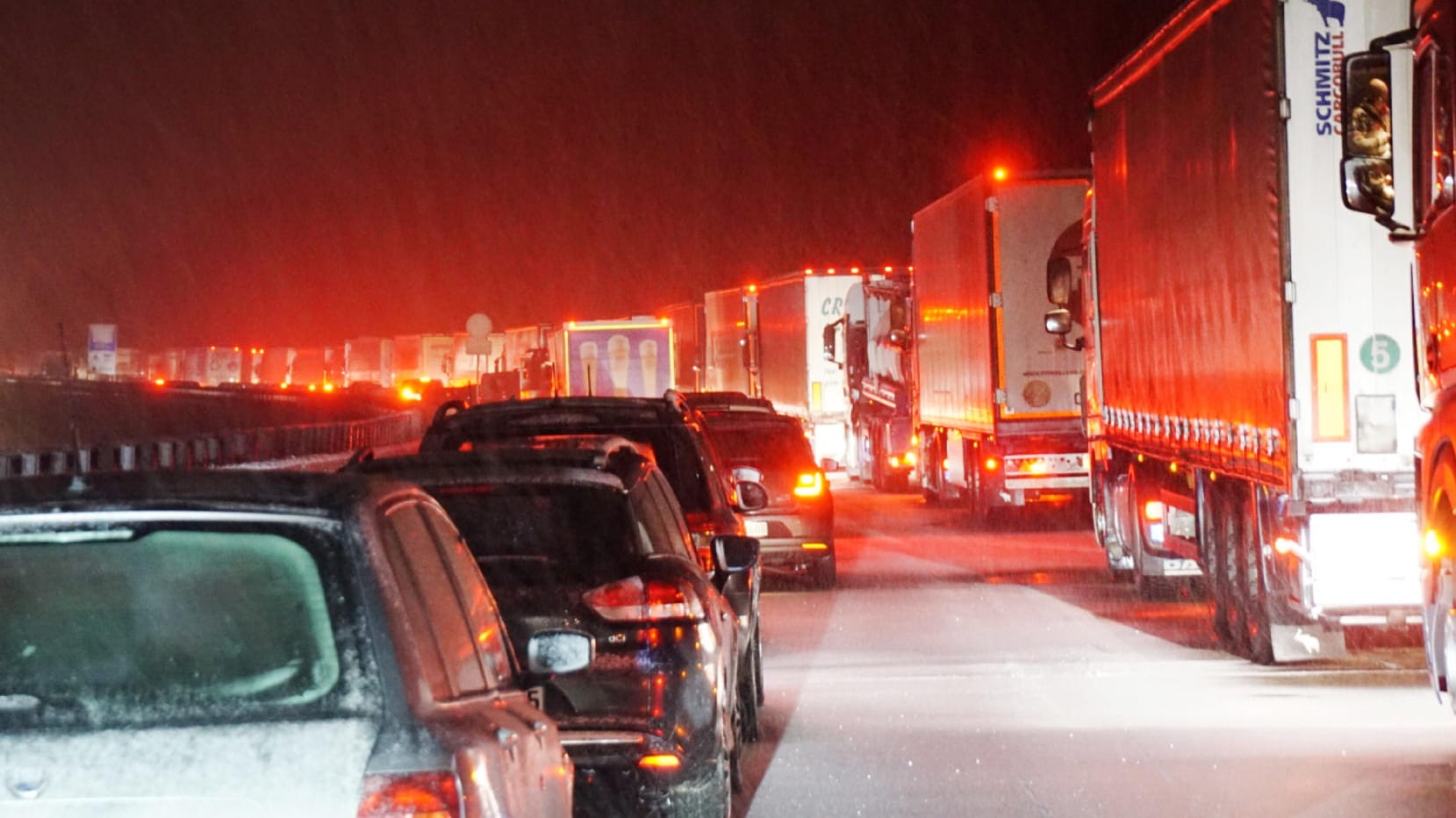 Baden-Württemberg: Nach starkem Schneefall stehen Autos und Lastwagen auf der mit Schnee bedeckten Autobahn A8.