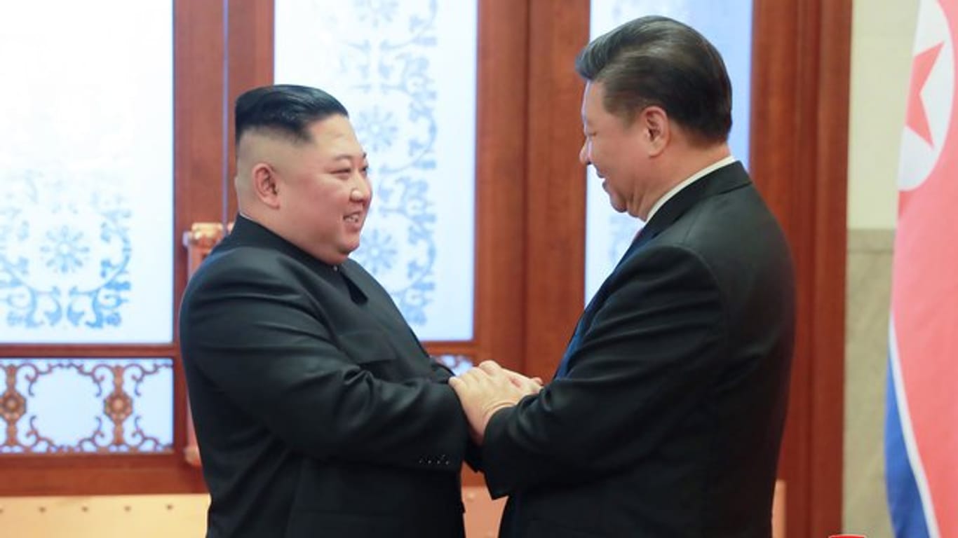 Kim Jong Un und Xi Jinping begrüßen sich in der Großen Halle des Volkes in Peking.