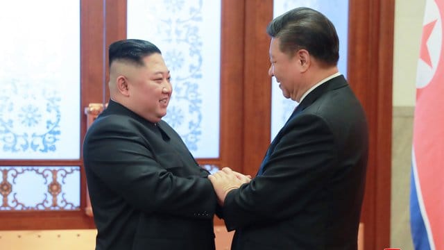 Kim Jong Un und Xi Jinping begrüßen sich in der Großen Halle des Volkes in Peking. Kim Jong Un und Xi Jinping begrüßen sich in der Großen Halle des Volkes in Peking.