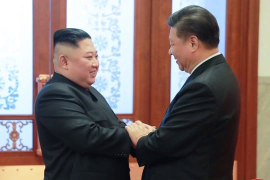 Kim Jong Un und Xi Jinping begrüßen sich in der Großen Halle des Volkes in Peking.