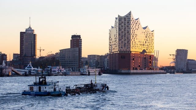 Die Elbphilharmonie leuchtet in der aufgehenden Sonne.