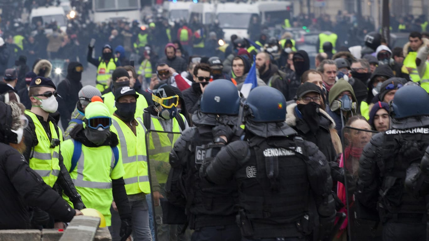 Vermummte Demonstranten stehen Polizisten gegenüber: Mit deutlich weniger Teilnehmern als noch vor einigen Wochen ist die "Gelbwesten"-Protestbewegung in Frankreich am vergangenen Samstag ins neue Jahr gestartet.