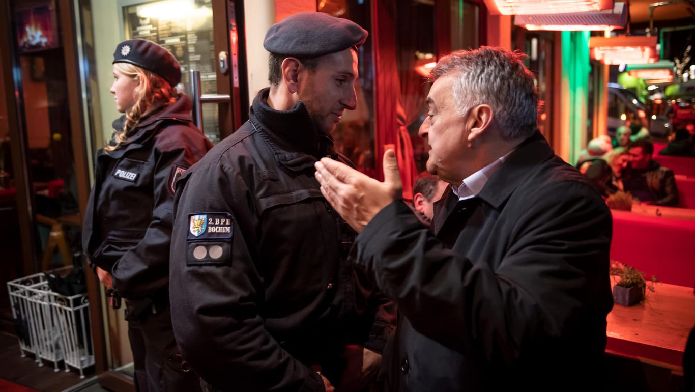 "Dulden keine rechtsfreien Räume": Herbert Reul (CDU, r.), Innenminister von Nordrhein-Westfalen, unterhält sich während der Razzia in einer Shisha-Bar in Bochum mit einem Polizisten.