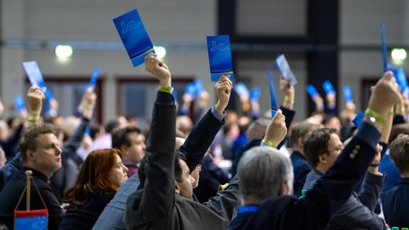 Delegierte halten bei der Europawahlversammlung der AfD in Riesa Stimmzettel hoch.