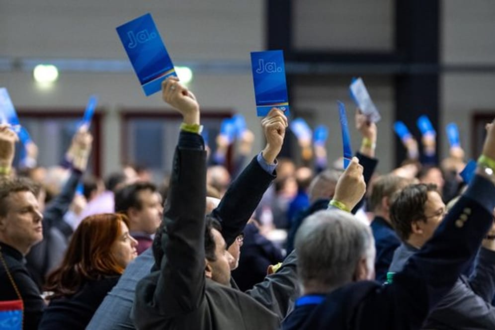 Delegierte halten bei der Europawahlversammlung der AfD in Riesa Stimmzettel hoch.