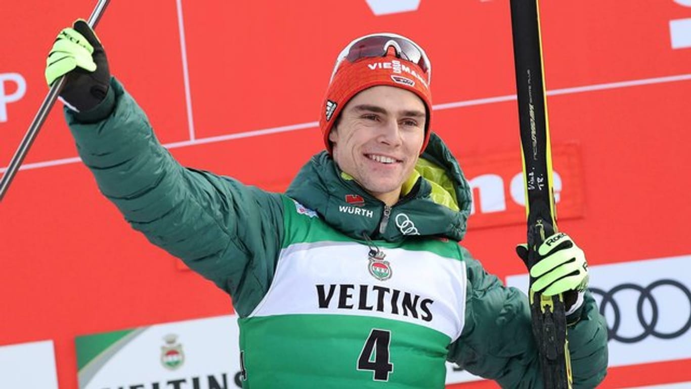 Der erstplatzierte Vinzenz Geiger jubelt auf dem Podium über seinen Sieg beim Weltcup in Val di Fiemme.