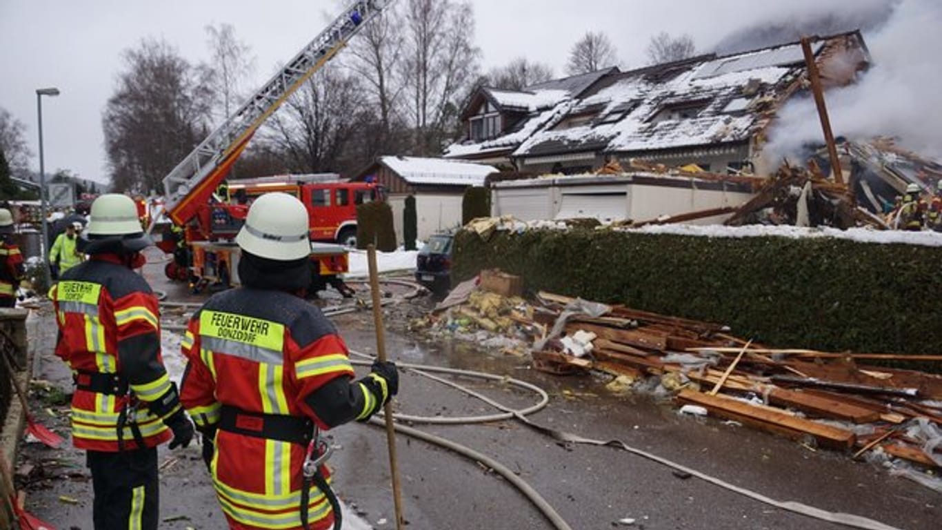 Feuerwehrleute stehen vor dem zerstörten Reihenhaus in Donzdorf.