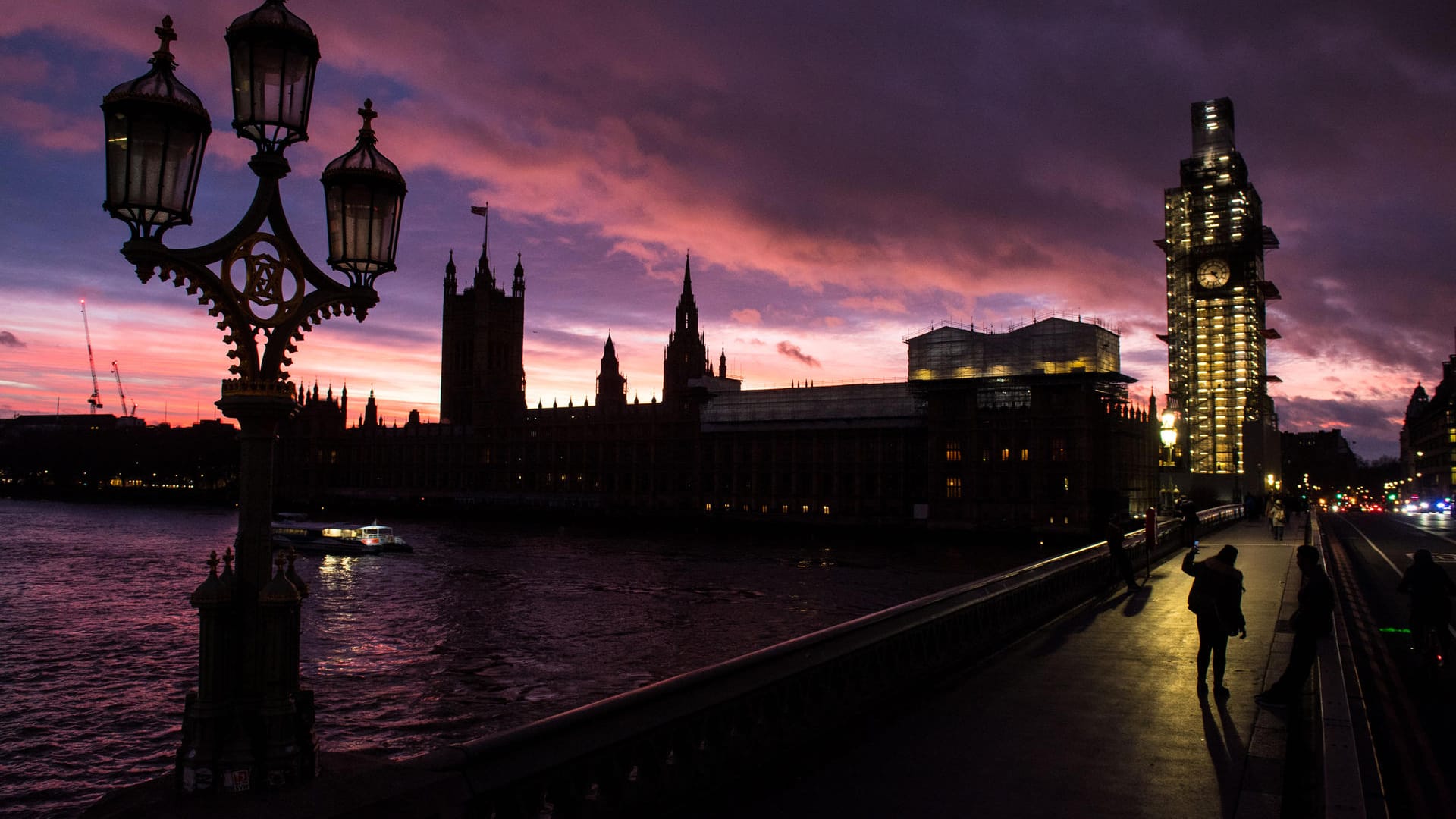 Ein Frau auf der Westminster Bridge macht ein Foto vom britischen Parlament im Abendlicht: Am Dienstag wird im Londoner Parlament über das Brexit-Abkommen abgestimmt.