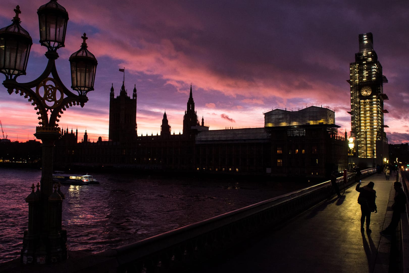 Ein Frau auf der Westminster Bridge macht ein Foto vom britischen Parlament im Abendlicht: Am Dienstag wird im Londoner Parlament über das Brexit-Abkommen abgestimmt.