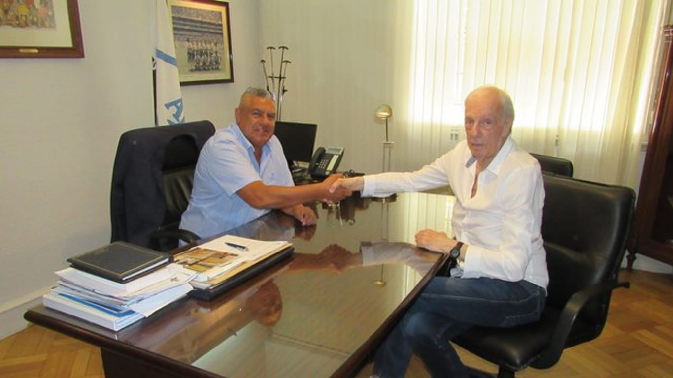 Cesar Luis Menotti (r) schüttelt Claudio Tapia, dem Chef des Argentinischen Fußballverbands (AFA) die Hand.