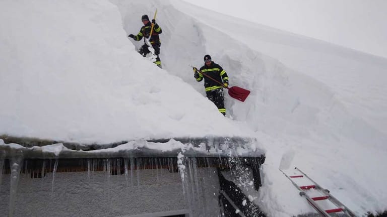 Feuerwehrkräfte räumen in Kirchdorf An Der Krems (Österreich) Schnee vom Dach eines Hauses: 41.000 Menschen sind allein im Bundesland Salzburg eingeschlossen.