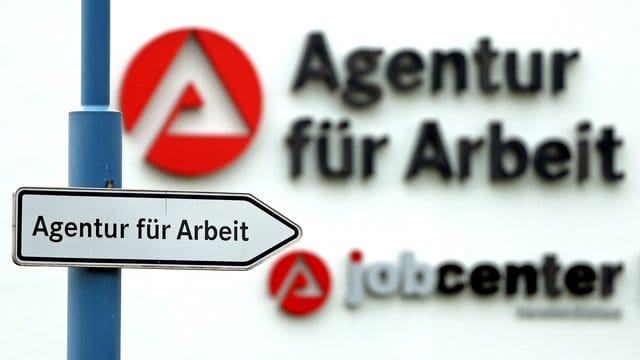 Ein Schild weist den Weg zur Agentur für Arbeit.