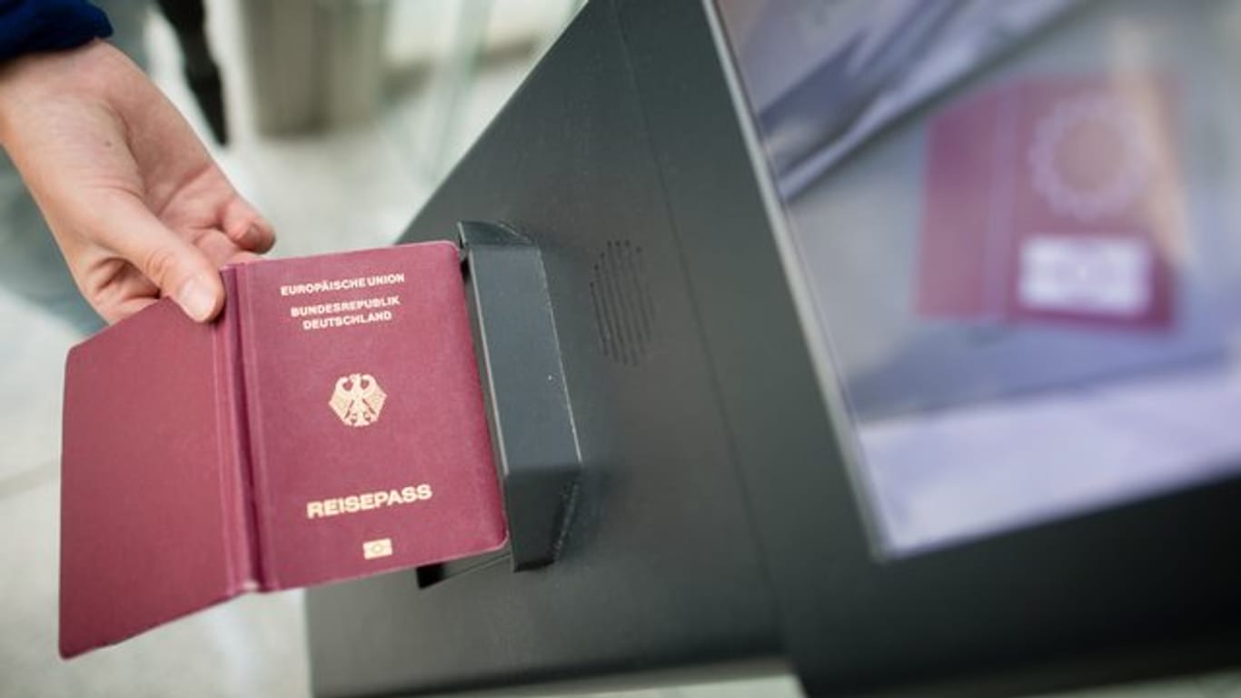 Eine Frau hält einen Reisepass an ein Lesegerät: Die EU will wieder verstärkt auf Ausweiskontrollen setzen.