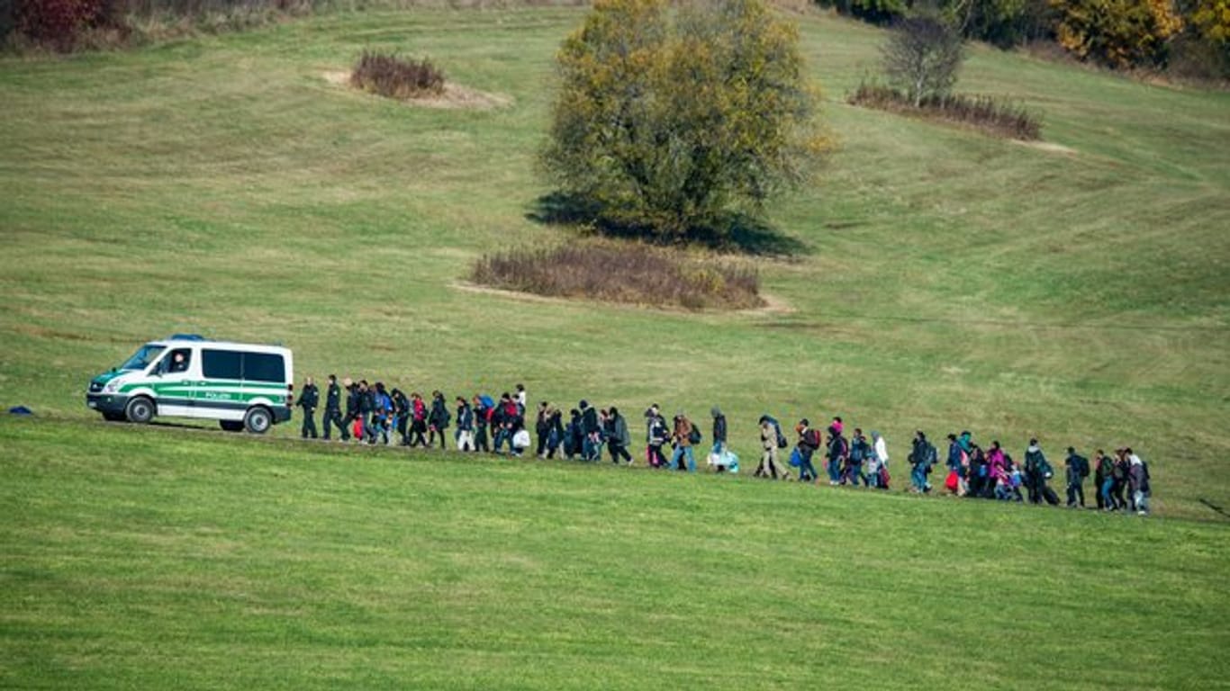 Flüchtlinge laufen hinter einem Fahrzeug der Bundespolizei im Jahr 2015.