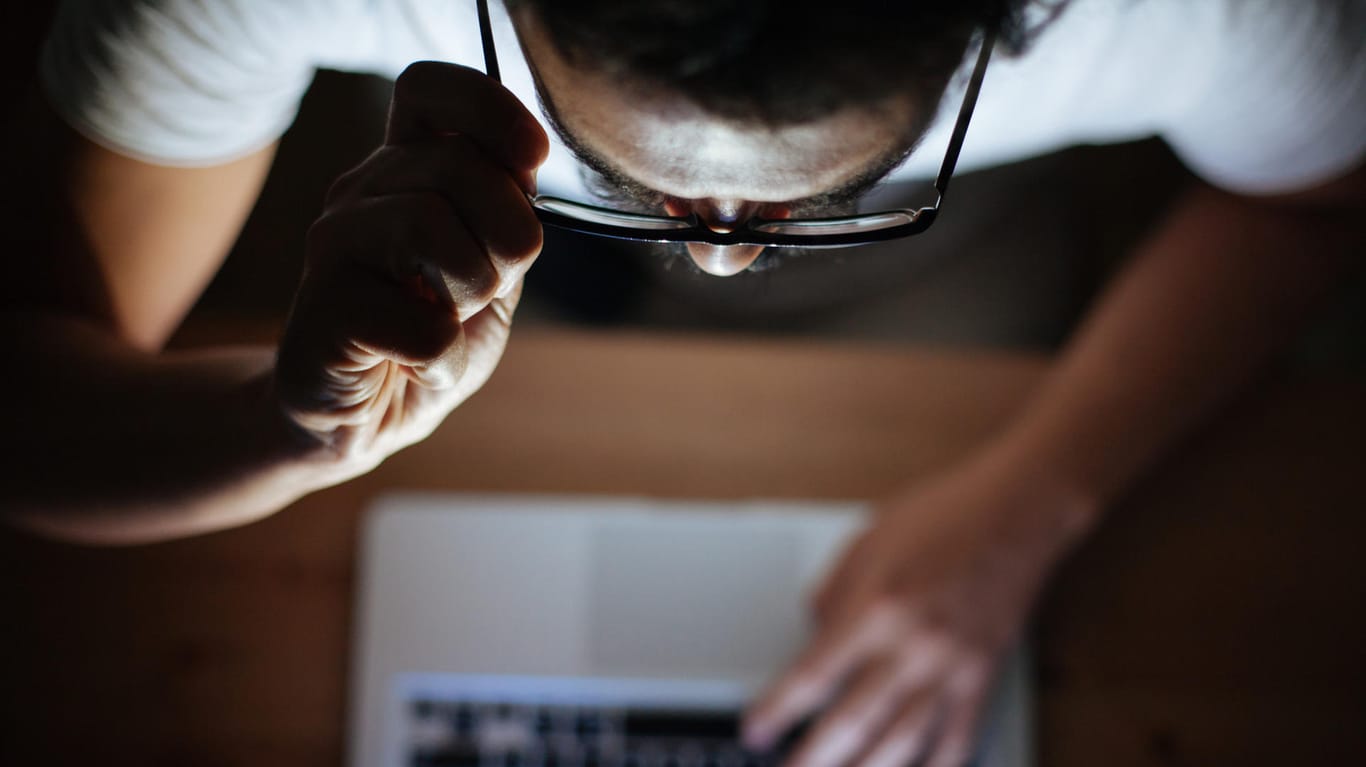 Ein Mann schaut auf seinen Rechner (Symbolbild): Derzeit kursieren Phishing-Mails in Namen verschiedener Institutionen im Netz.