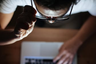 Ein Mann schaut auf seinen Rechner (Symbolbild): Derzeit kursieren Phishing-Mails in Namen verschiedener Institutionen im Netz.