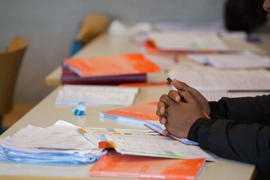 Arbeitsmaterialien auf dem Tisch einer Vorbereitungsklasse mit Flüchtlingen.