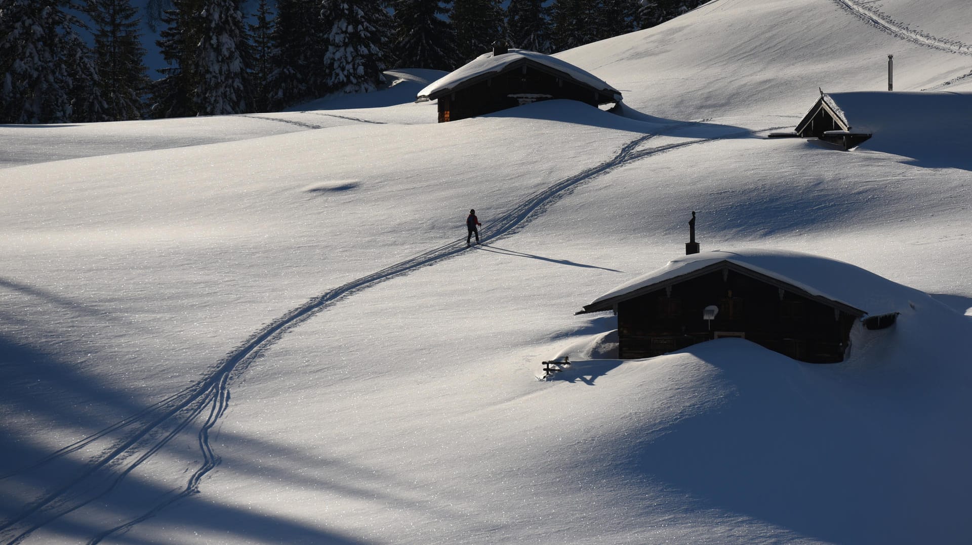 Ein Skitourengeher spurt in Bayern zwischen Berghütten den Hang hinauf: Laut Meteorologen komme die vereinzelte Schneehöhe von bis zu zwei Metern alle 30 bis 50 Jahre vor. Ein Skitourengeher spurt in Bayern zwischen Berghütten den Hang hinauf: Laut Meteorologen komme die vereinzelte Schneehöhe von bis zu zwei Metern alle 30 bis 50 Jahre vor.