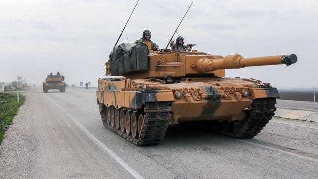 Ein türkischer Panzer vom Typ Leopard 2A4 fährt in der Nähe der syrischen Grenze auf einer Straße. Ein türkischer Panzer vom Typ Leopard 2A4 fährt in der Nähe der syrischen Grenze auf einer Straße.
