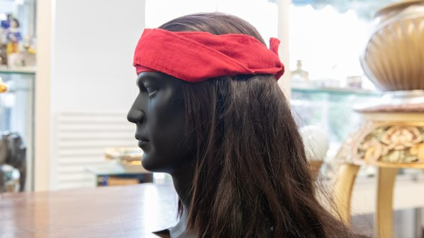 Ein Kopfmodell mit einer Perücke von Winnetou-Darsteller Pierre Brice steht in einem Auktionshaus auf einem Tisch.